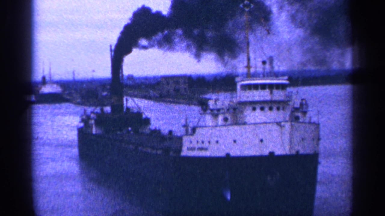 Ship viewed closer from the front as smoke trails across the sky.