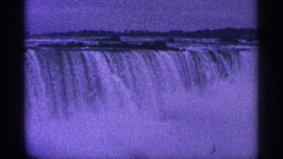 1964 8mm Niagara Falls view showing sheets of water descending with mist below and a distant horizon.