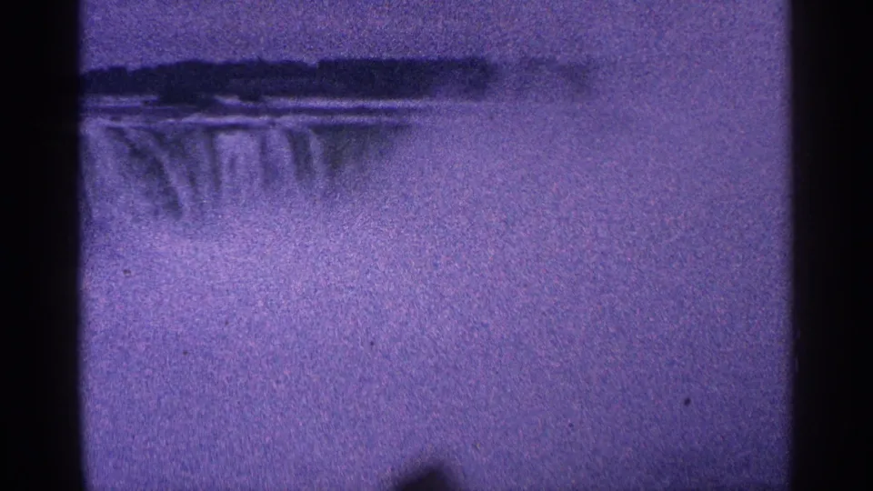 A distant 8mm view of Niagara Falls shows the cascade partly softened by thick mist, with treeline and scan borders visible.