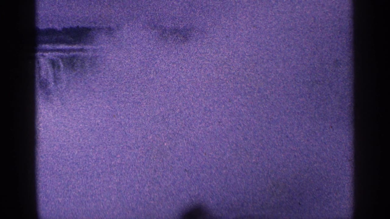 Misty waterfall surface with dark vertical film bars and grain.