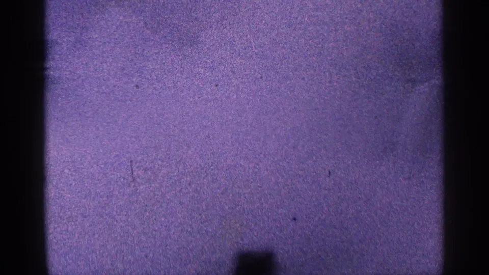 1964 8mm frame from Niagara Falls, Canada, with a low-contrast purple wash, mist, grain, and partial dark film borders.