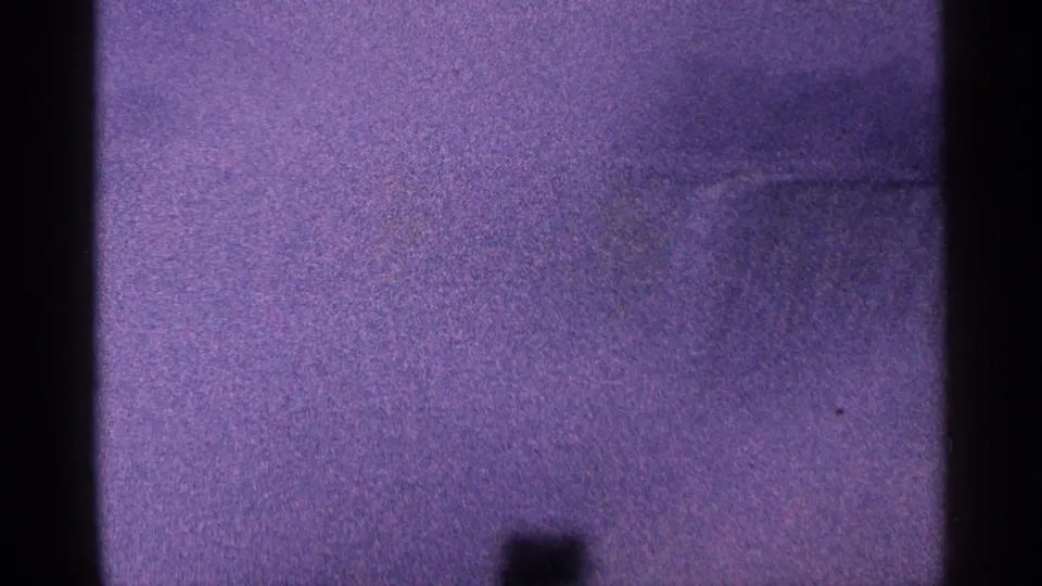 Final 1964 Niagara Falls home-movie frame with purple-tinted mist, faint cascade detail, film grain, and dark scan borders.