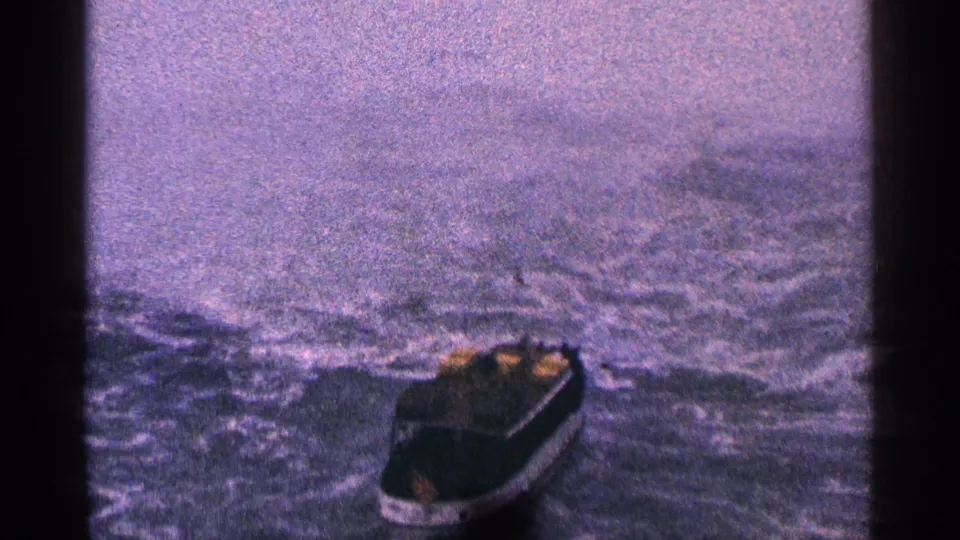 The boat is closer in frame on rough Niagara River water, with mist from the falls filling the background in the 1964 home-movie shot.
