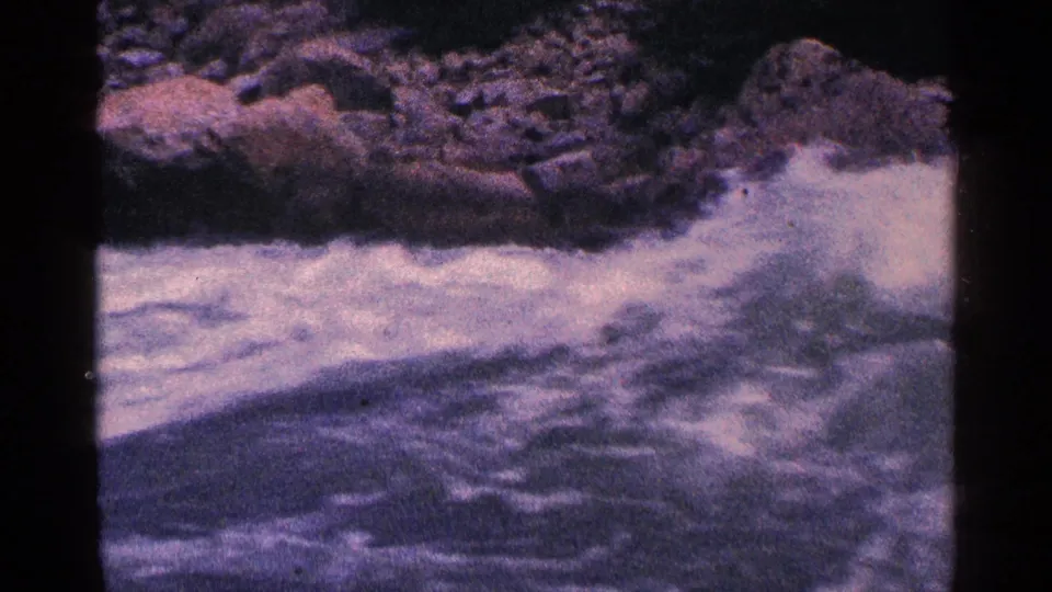 A close 8mm view of churning water and shoreline rocks at Niagara Falls, Canada, from the supplied 1964 home-movie footage.