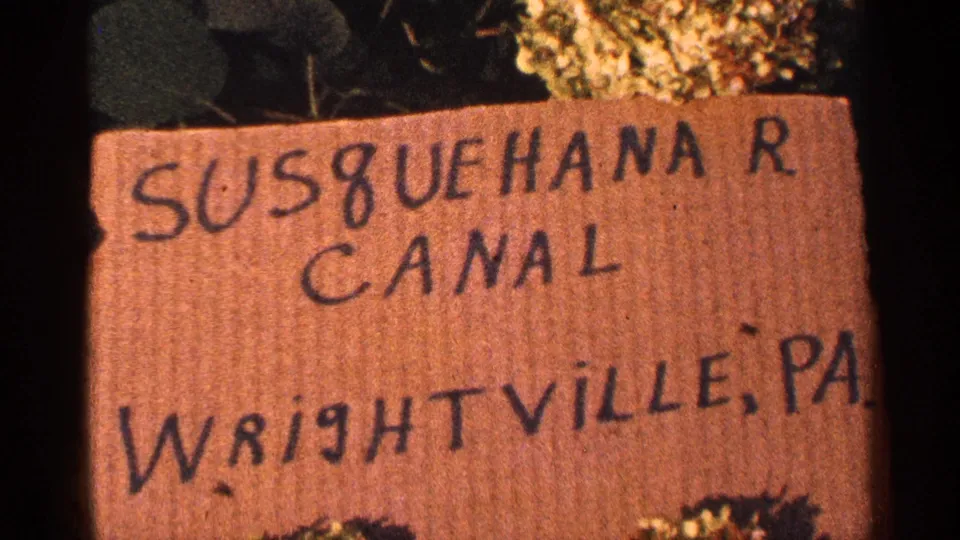 1964 Pennsylvania 8mm frame where the Susquehanna River Canal sign fills most of the view, with Wrightville, PA written below.