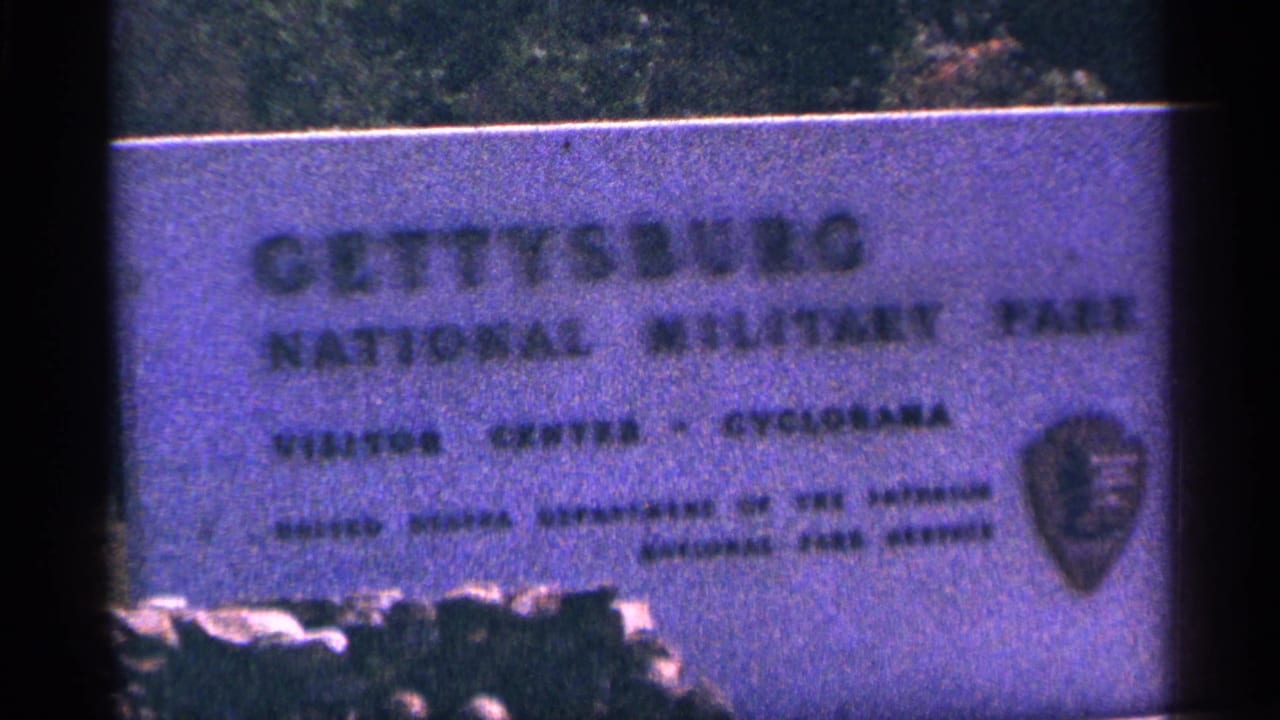 1964 8mm frame showing the Gettysburg National Military Park visitor center sign with a National Park Service shield.