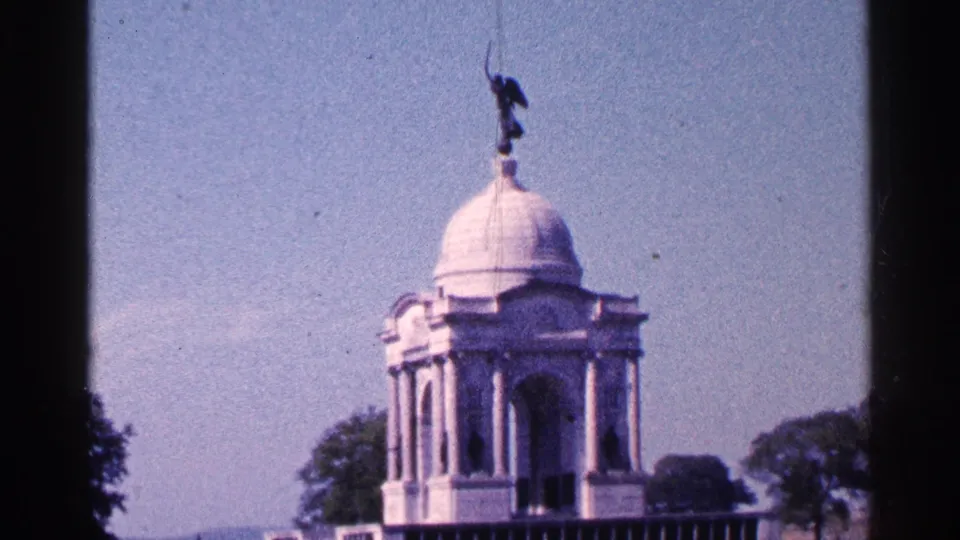 1964 Pennsylvania frame with the domed monument slightly lower in view, showing columns, statue, trees, and open sky.