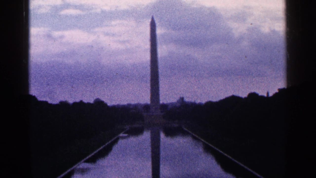 Washington Monument reflected in the Reflecting Pool beneath a cloudy sky.