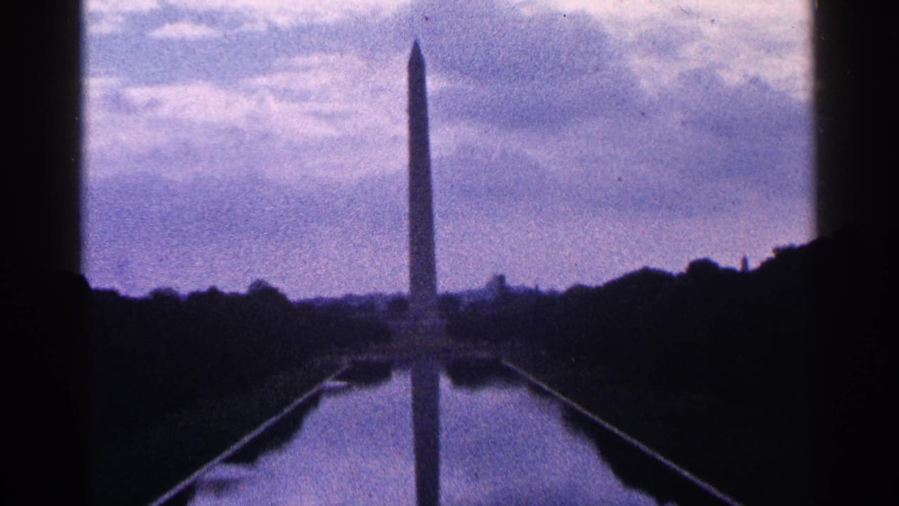 Washington Monument and Reflecting Pool framed by dark trees and film borders.