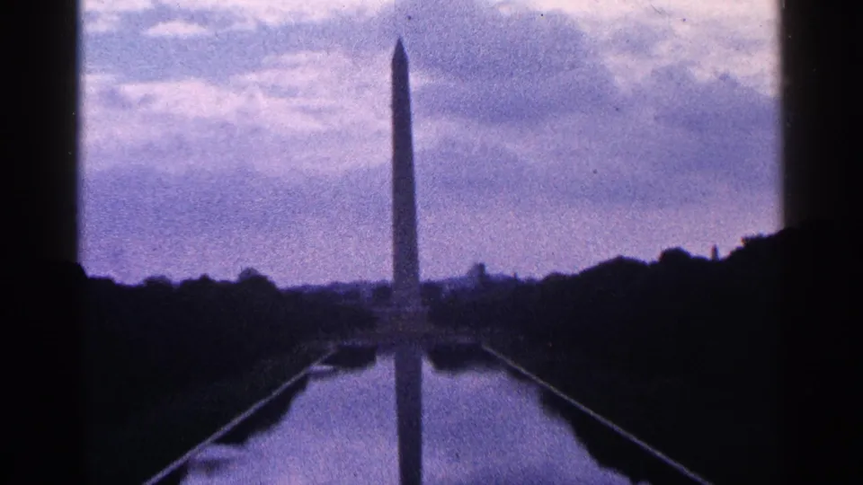 1964 Washington, D.C. frame with the Washington Monument centered beyond the Reflecting Pool in soft 8mm color.