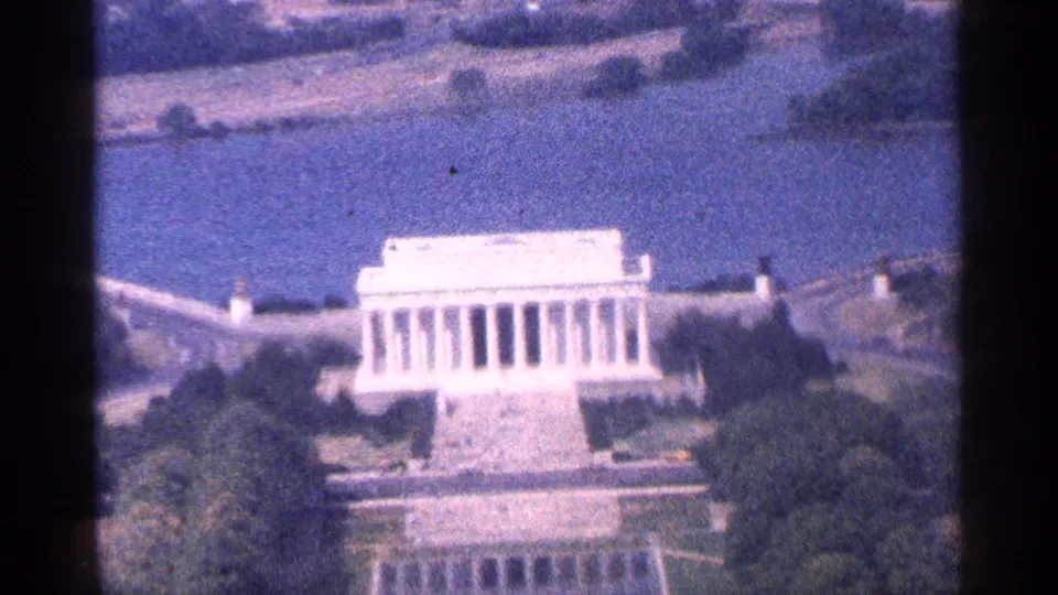 1964 8mm aerial frame of the Lincoln Memorial in Washington DC, with the Reflecting Pool area, trees, and surrounding walkways visible.