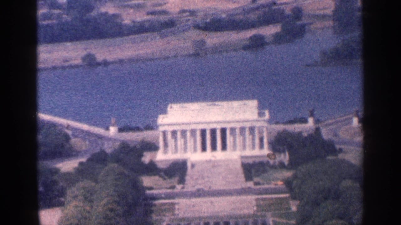 Aerial view of the Lincoln Memorial beside water and surrounding trees.