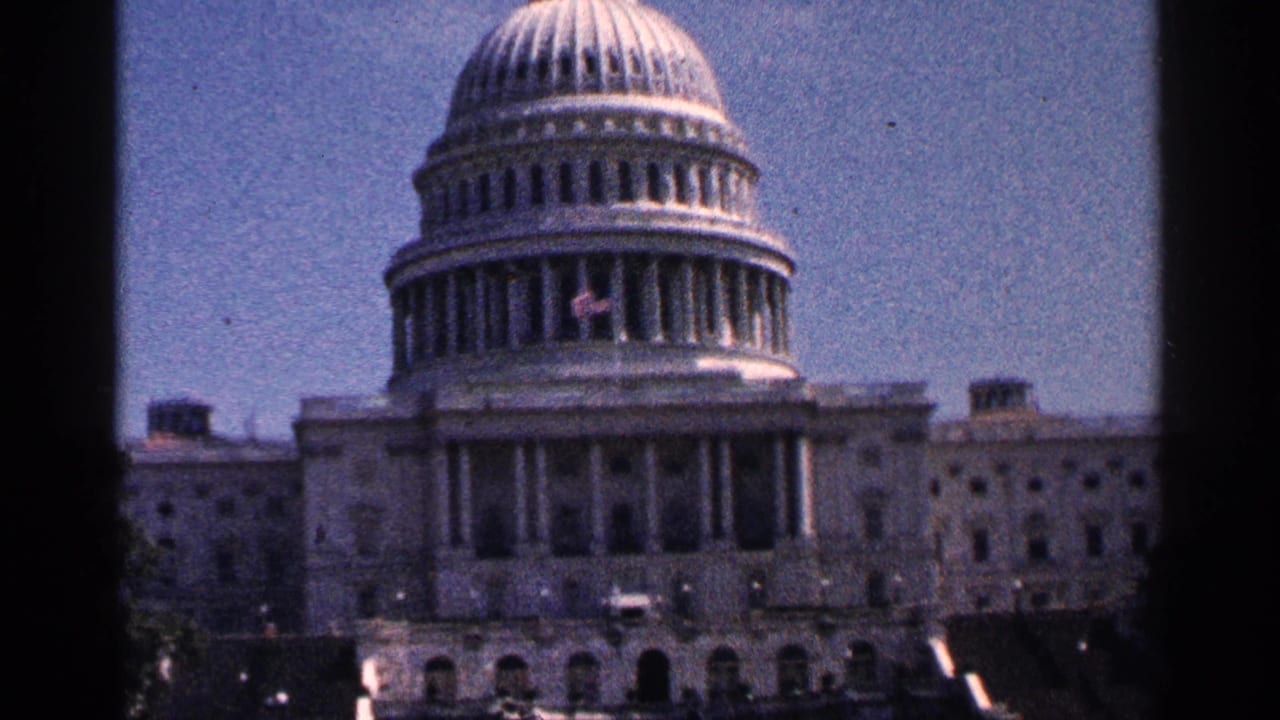 Closer view of the U.S. Capitol dome and facade under a blue sky.
