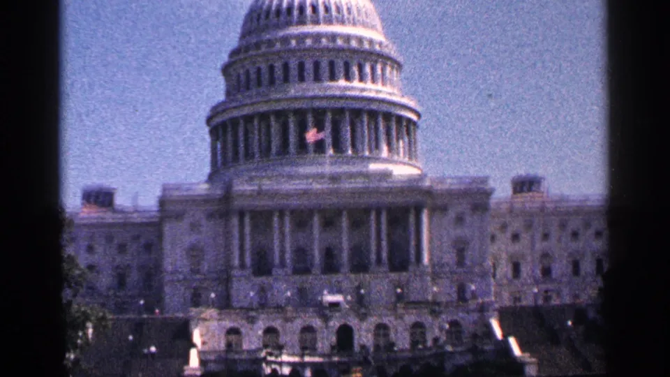 Visitor-shot 8mm view of the U.S. Capitol in Washington, D.C., with dome, columns, steps, and soft grain visible.