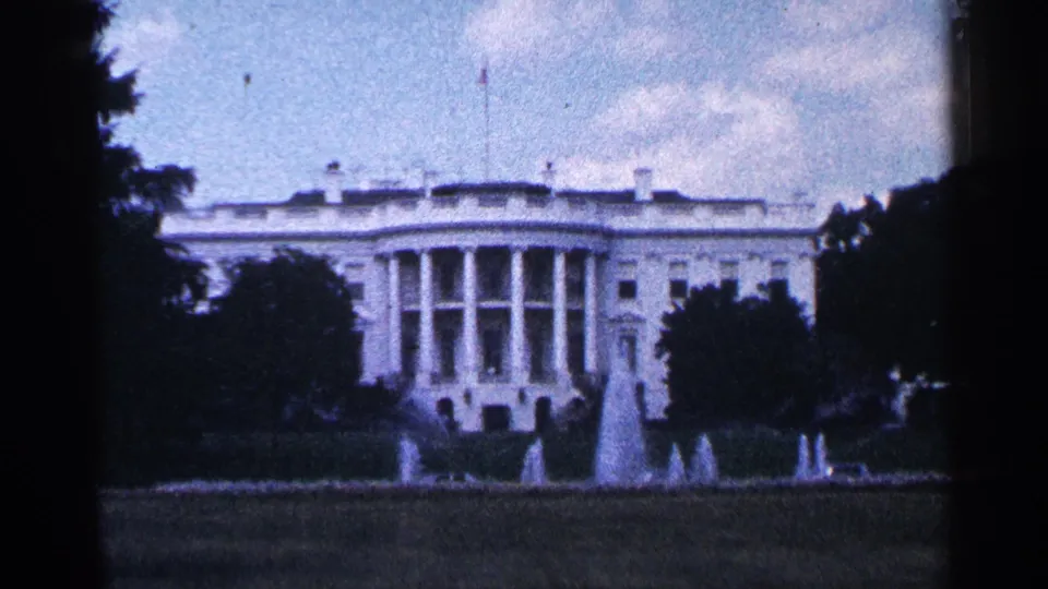 1964 8mm view of the White House in Washington DC, showing the south facade, lawn, fountains, trees, and soft faded color.