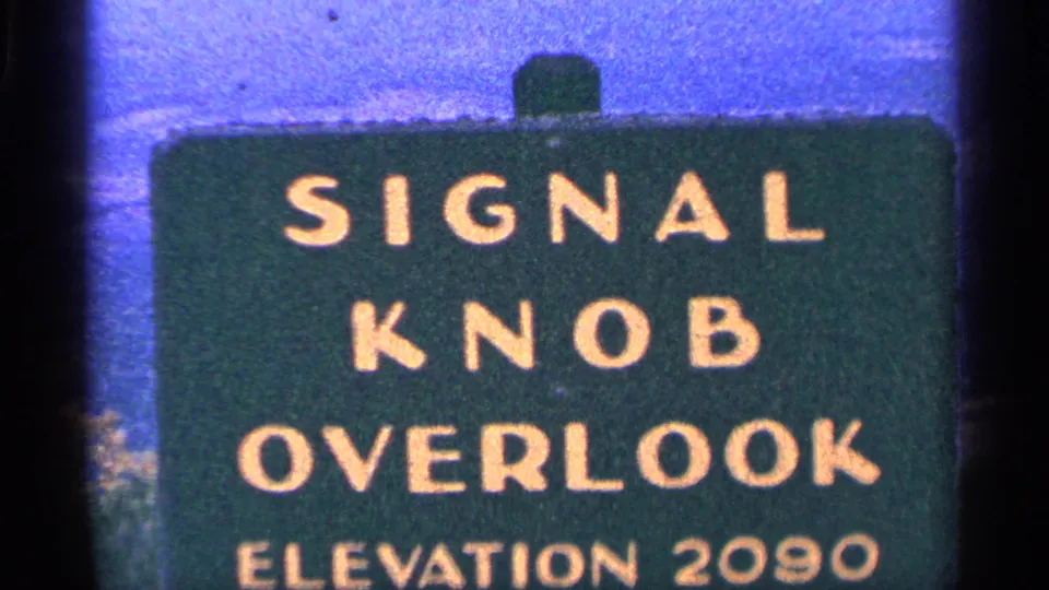 1964 8mm frame of the Signal Knob Overlook sign, tightly framed with the elevation line visible along the lower edge.