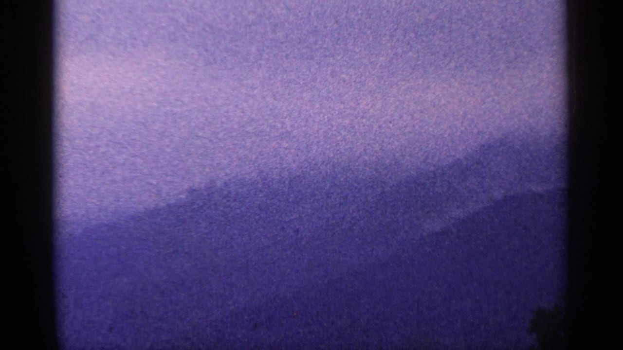 Purple hazy mountain ridge under a pale sky with dark 8mm frame edges.
