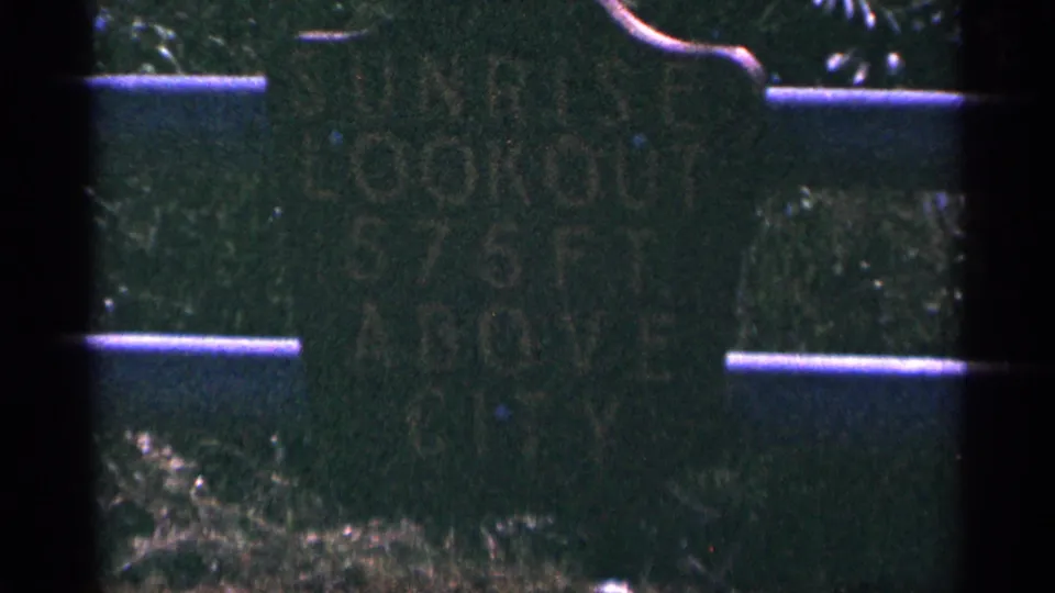 The final frame holds on the Duluth Sunrise Lookout sign, with faded lettering and surrounding grass visible.