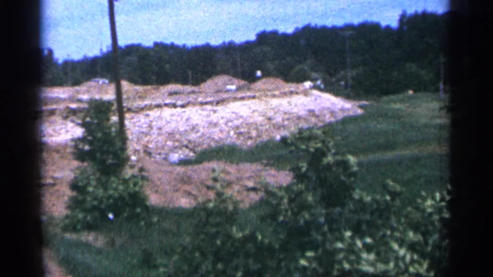 The final frame looks over a graded or excavated area in Duluth, with grass in the foreground and cars near the far edge.