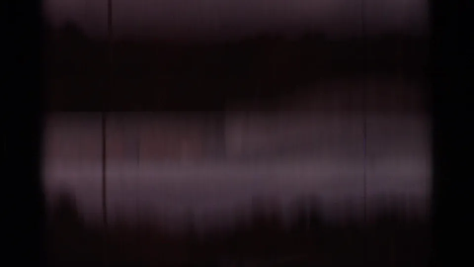 Dark late frame from the 1965 Duluth 8mm clip, with faint water reflections and vertical film marks visible.