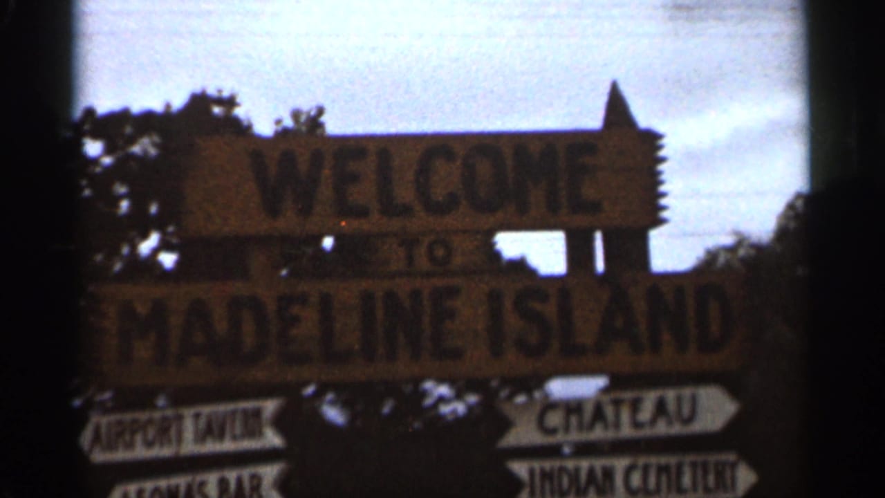 Wooden welcome sign for Madeline Island with arrow boards below.