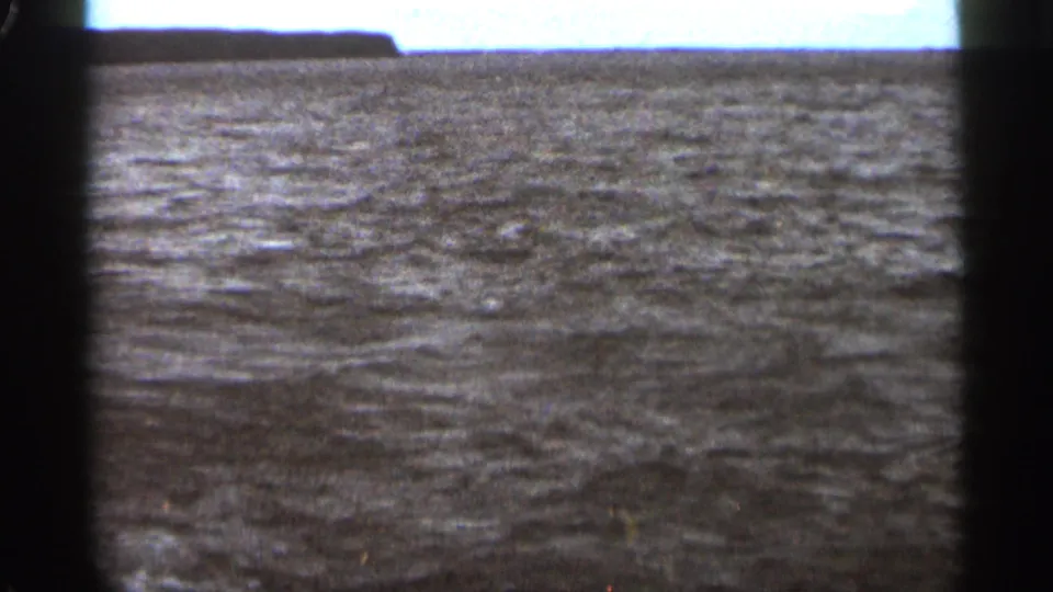 Choppy water near Duluth in the 1965 metadata context, with a flat horizon and dark 8mm frame-divider shadows.