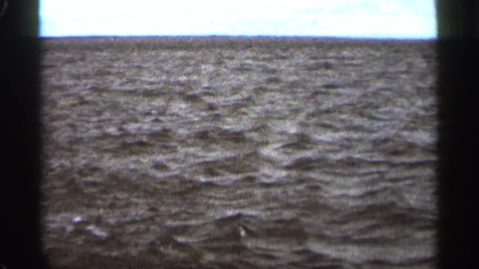 Fixed 8mm view of rough open water in the 1965 Duluth clip, with bright surface highlights and visible film edges.