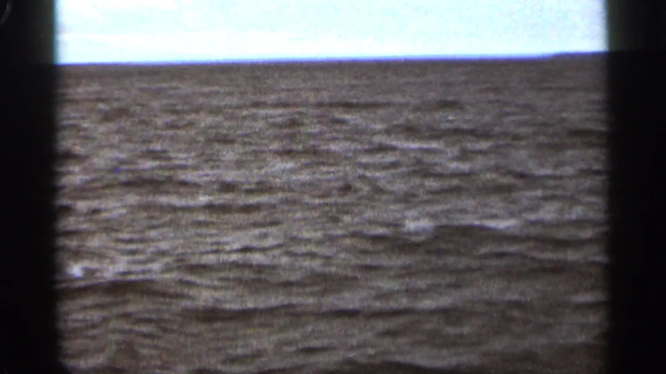 The final sampled frame shows choppy Duluth-area open water, a pale sky, and strong black 8mm frame borders.