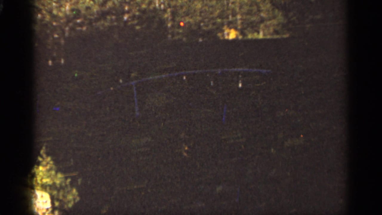 Faint arched structure over dark water with scattered light artifacts.
