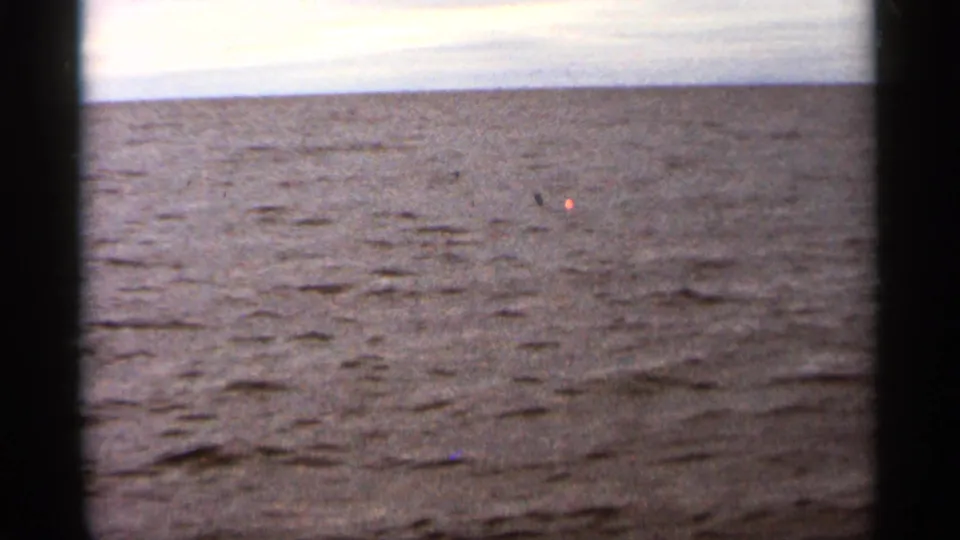 Duluth-area Lake Superior water appears in a soft 1965 8mm frame with small waves and an overcast horizon.