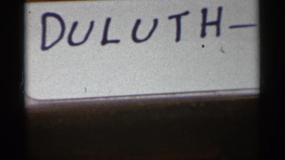 Another 1965 Duluth title-card frame, showing the handwritten location label cropped close.