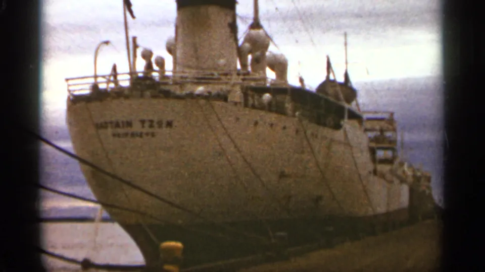 1965 Duluth harbor footage showing the named Captain Tzun ship from a low visitor viewpoint at the dock.
