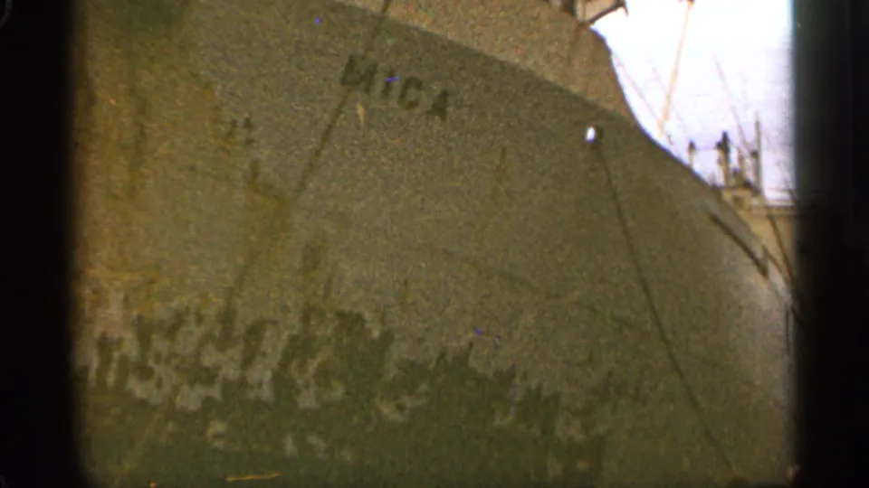 1965 Duluth 8mm frame of the weathered Mica bow, shot close from below with rigging and deck details visible.