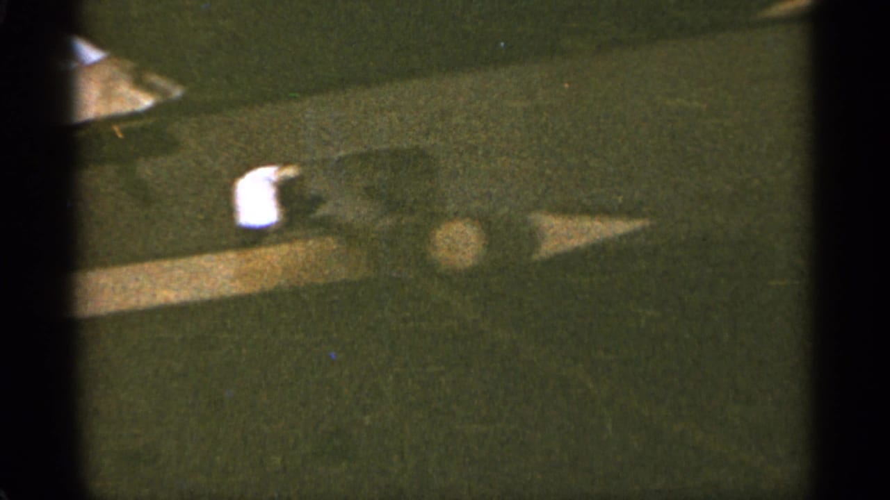 Close view of a dark ship hull with a small white deck object and heavy film edge shadow.