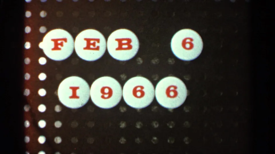 8mm home-movie frame holding on the FEB 6 1966 date card, with visible grain, warm color shift, and perforation marks at the edge.