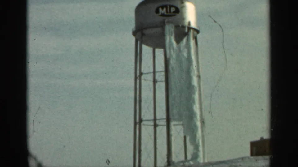 Duluth, Minnesota 8mm frame showing a silver water tower against a pale sky, with an MIP logo visible on the tank.
