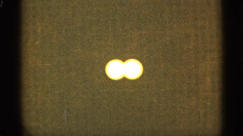 A pair of blurred yellow-white lights sits in the lower portion of the frame, with visible grain and warm 8mm color from the Duluth 1965 metadata context.