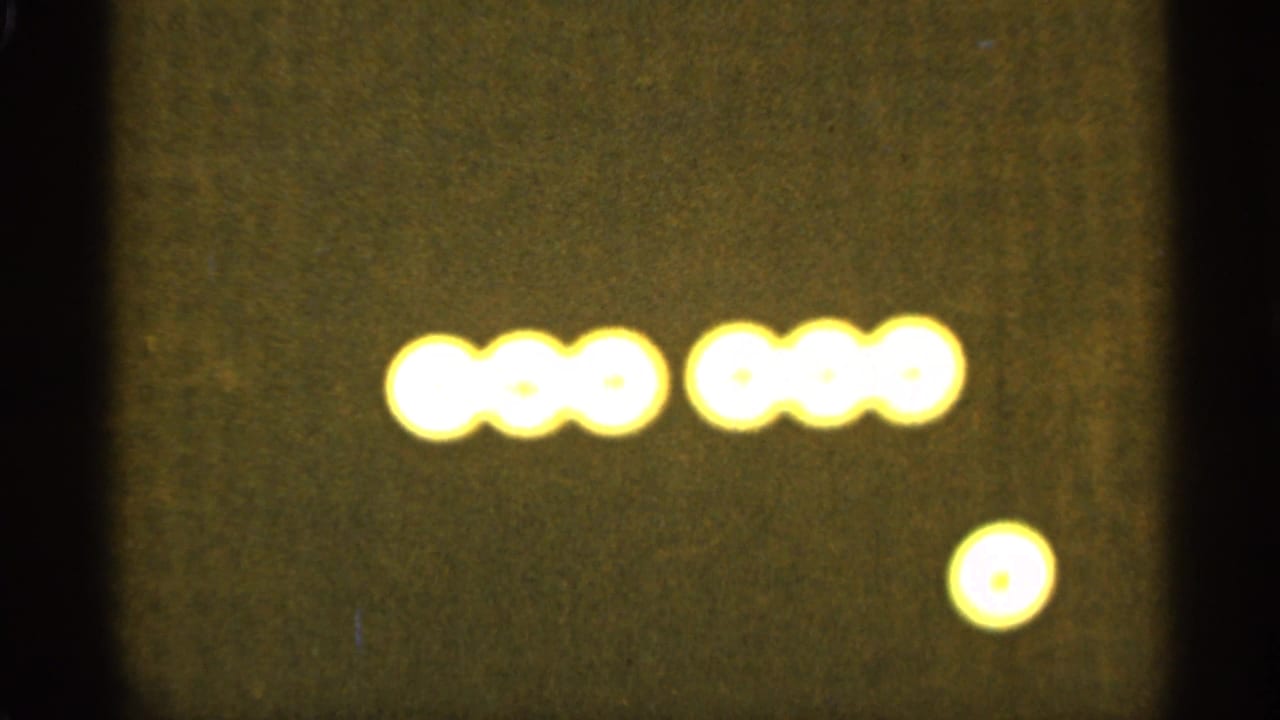 Yellow glowing dots arranged in two short rows on a dark screen.