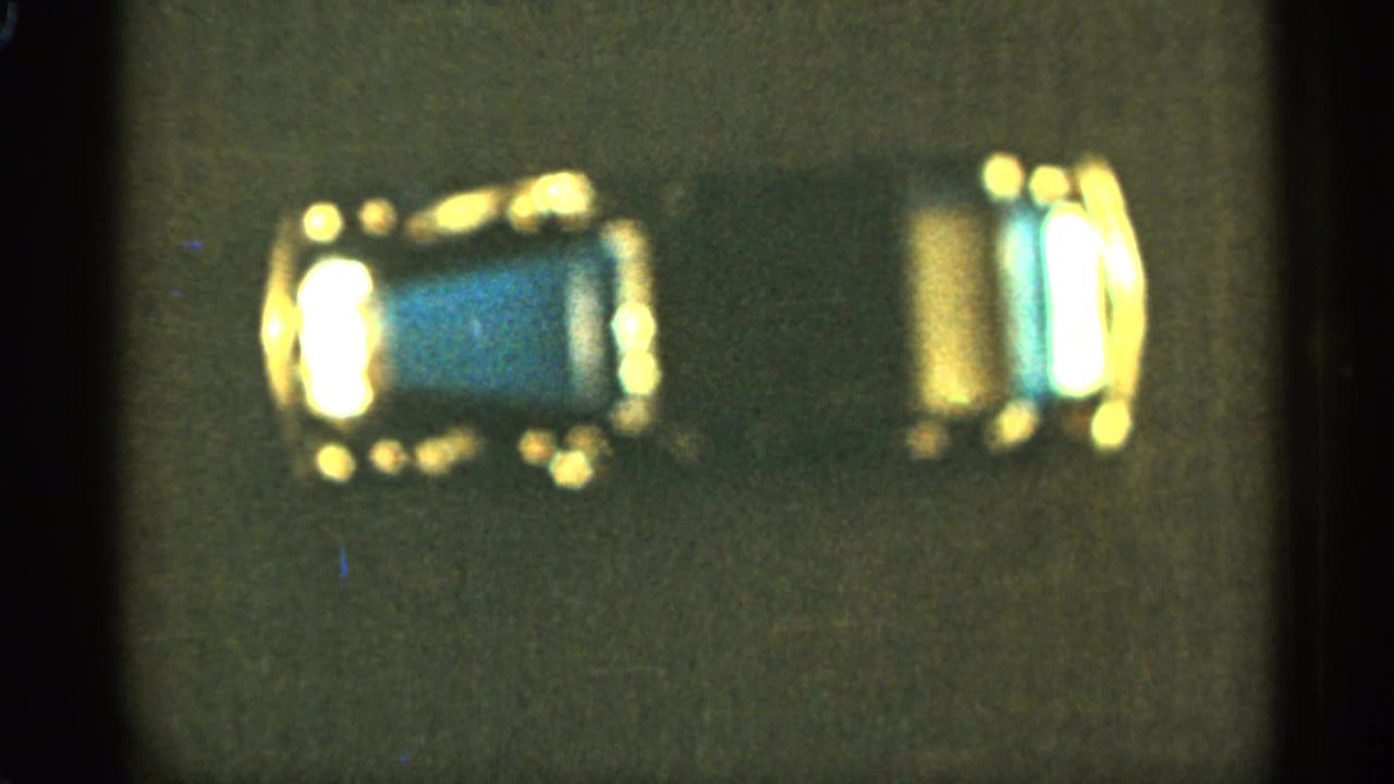 Reflective blue toy car and gold-toned section on a dark background.