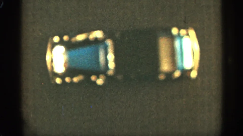 1965 Duluth 8mm still showing the blue-and-gold toy car in soft focus with visible film grain.