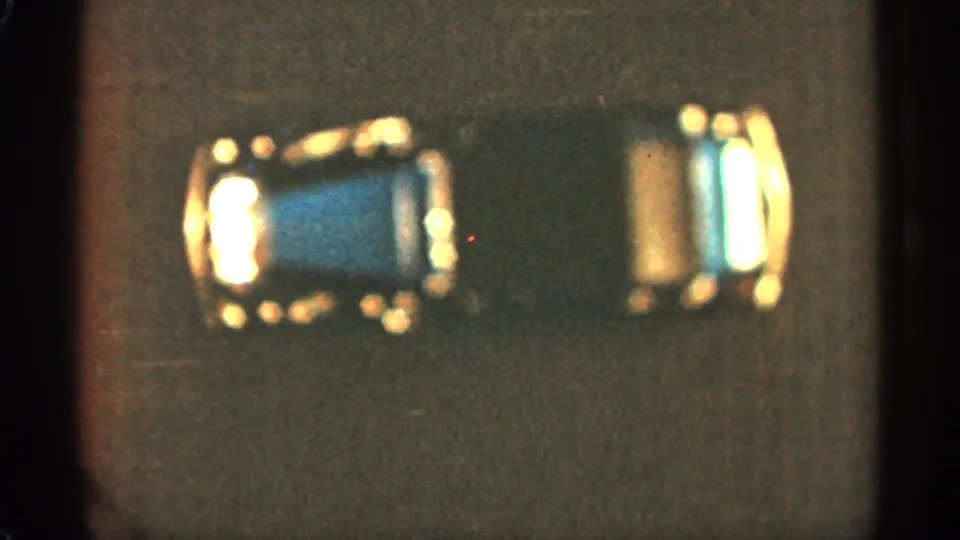 Final 1965 Duluth frame of the reflective toy car, softened by warm exposure, grain, and 8mm gate edges.