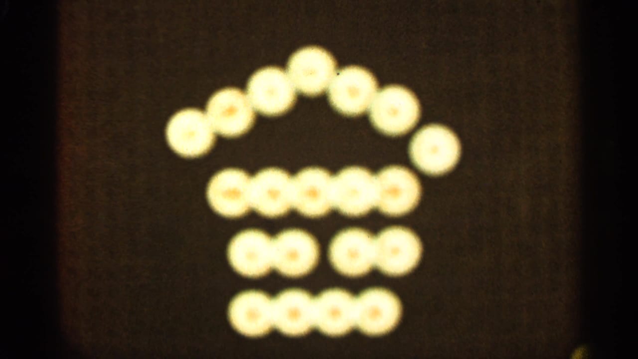 Glowing circular lights form a house-like shape against a dark background.