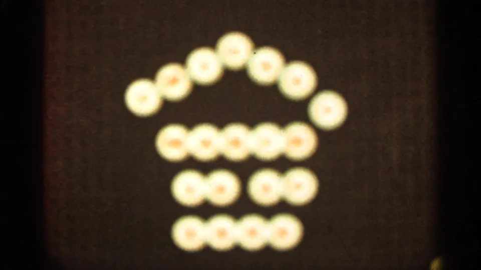 In this 1965 Duluth 8mm frame, the light pattern remains in a house-like arrangement with a curved top and stacked rows below.