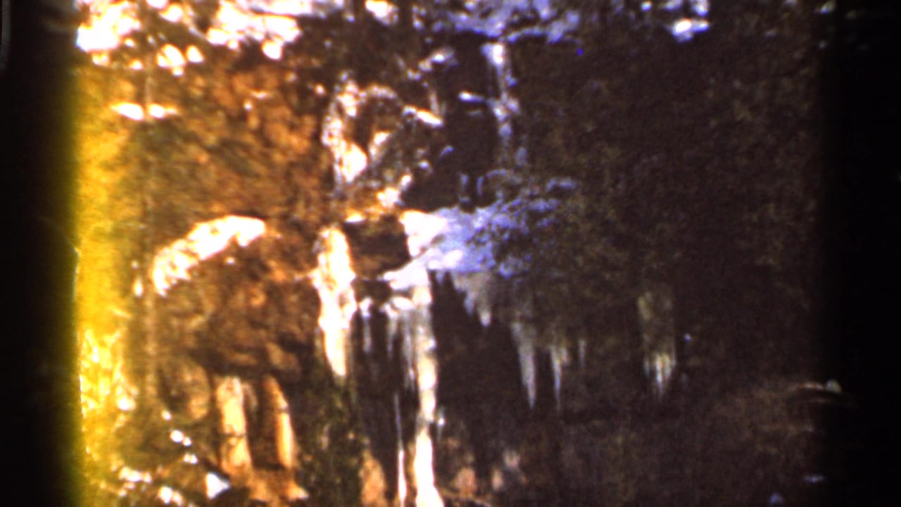 Snow-covered trees and hanging icicles in Eau Claire, Wisconsin, seen through grainy 1966 8mm home-movie exposure.