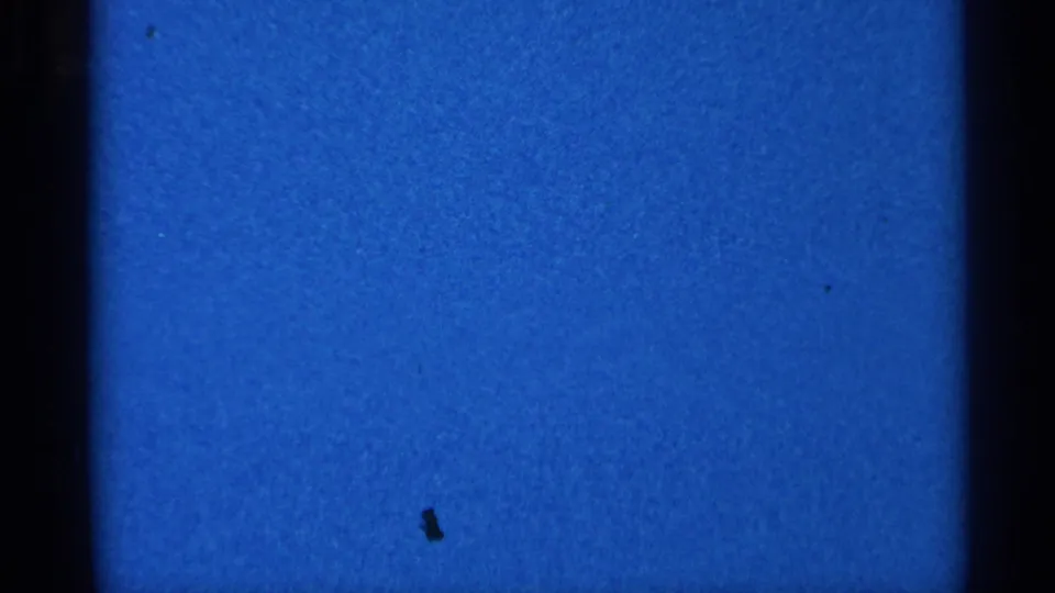 Blue leader or blank 8mm frame following the Eau Claire winter scene, with grain and dark film edges visible.