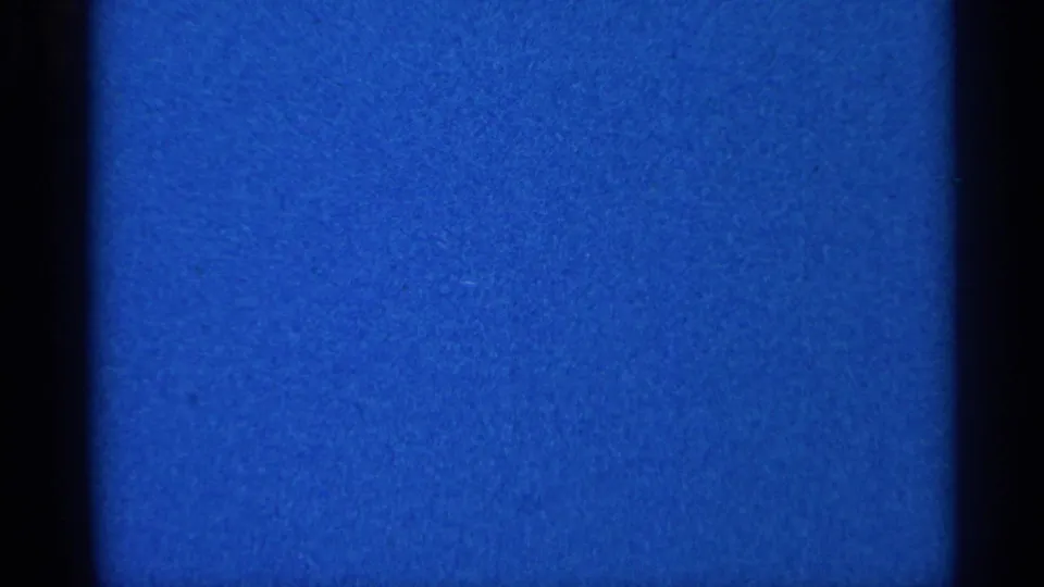 Static blue 8mm film texture from the 1966 Eau Claire, Wisconsin reel, with dark side borders and visible grain.