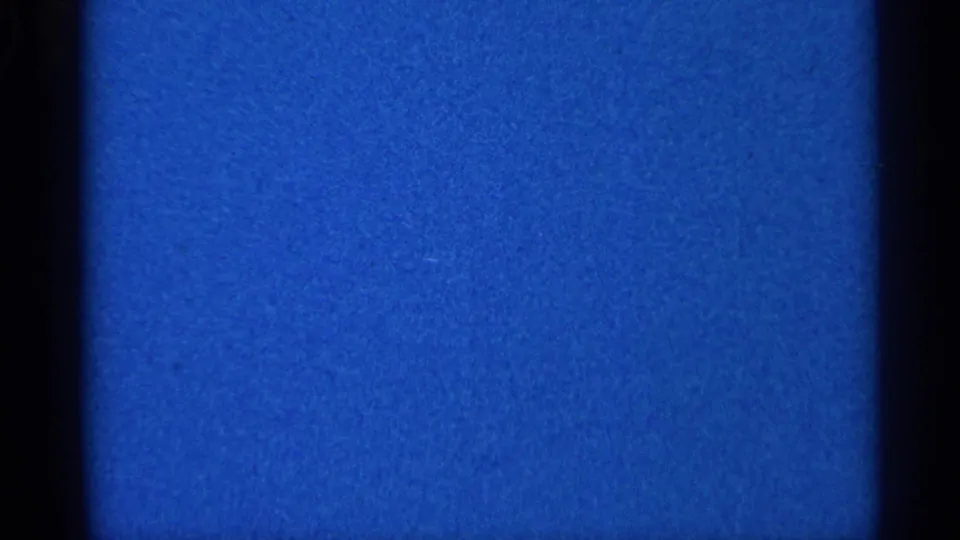 Blue 8mm frame from the Eau Claire 1966 home-movie material, showing grain, tonal variation, and dark gate borders.