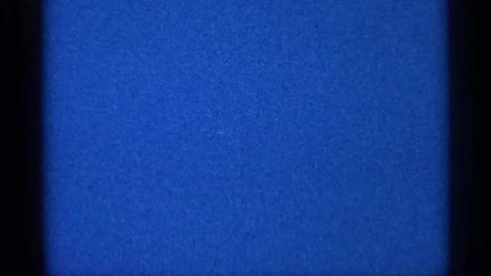 Static blue 8mm texture from the 1966 Eau Claire reel, with a horizontal contact-sheet seam, grain, and dark side borders.
