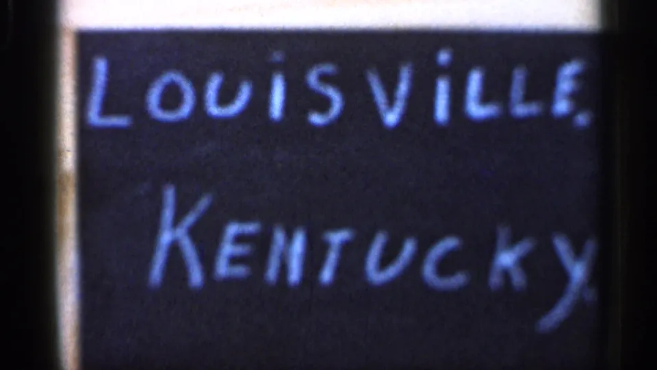 Soft 8mm frame of a handwritten Louisville, Kentucky chalkboard title, used as a personal travel marker.