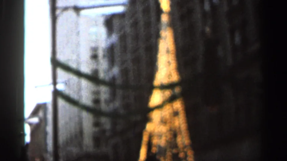 Final 1966 Florida 8mm frame shows the illuminated tower-like structure blurred behind dark framing and nighttime light bloom.